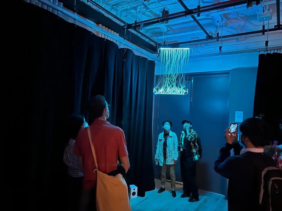Visitors gathered around the suspended Light Wave installation at the ITP Spring Show